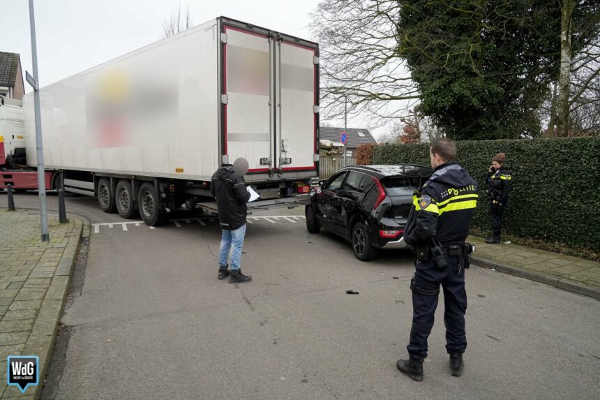 Draaiende vrachtwagen duwt geparkeerde auto de stoep op