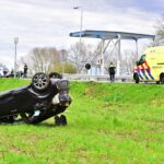 Auto op de kop in akker bij Ospel