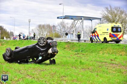 Auto op de kop in akker bij Ospel